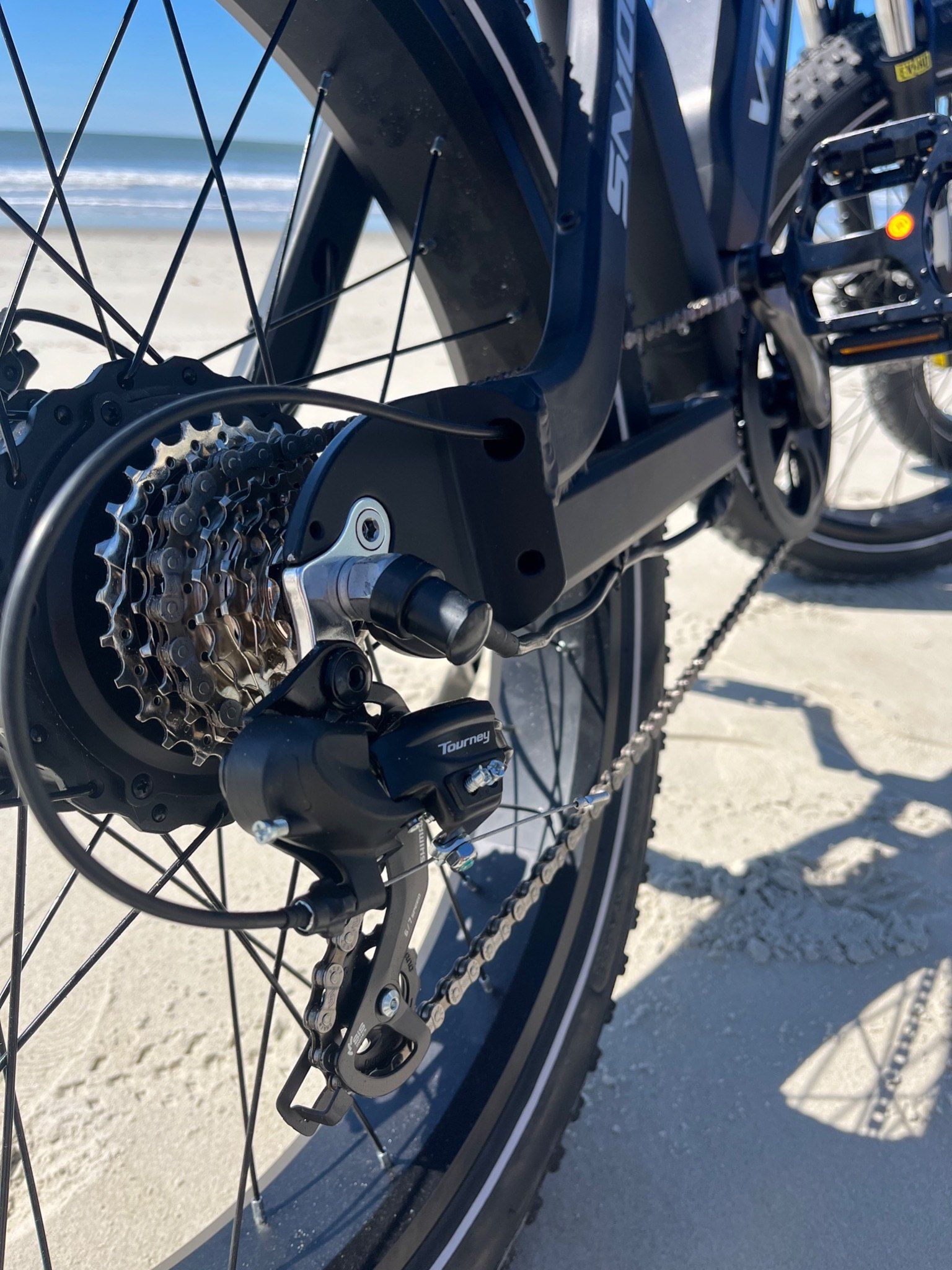 Close-up of the rear gear cassette and derailleur on a dark e-bike